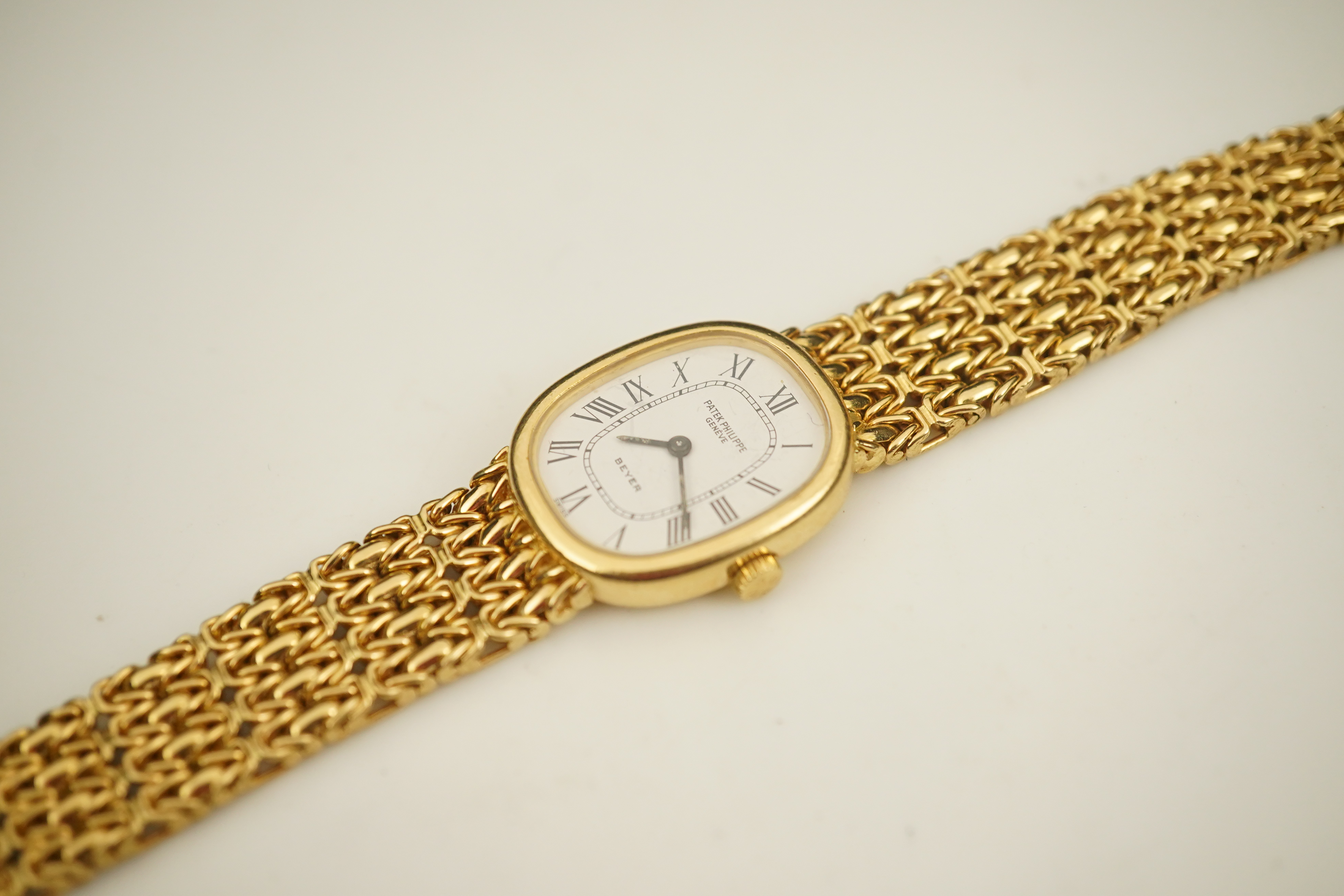 A lady's 18ct gold Patek Philippe manual wind wrist watch, on an integral 18ct gold Patek Philippe bracelet